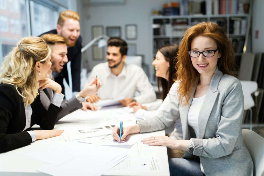 Group fo office workers around a table, looking happy