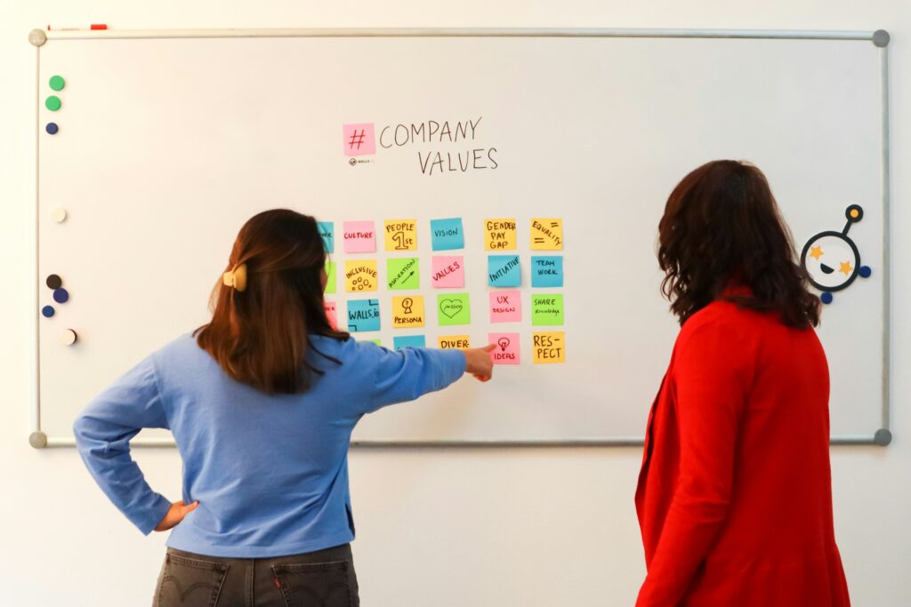 Photo by Walls.io on Unsplash Two women looking at post it notes of values